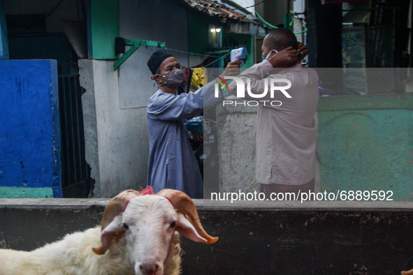 Indonesian muslims wearing protective mask check the body temperature as they attend the Eid Al Adha prayer during the COVID-19 emergency re...