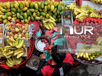 A vendor packs Peaches for a customer at a market ahead of Muslim festival Eid-Ul-Adha in Sopore District Baramulla Jammu and Kashmir India...
