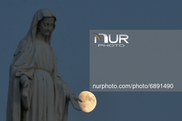 View of the moon and the statue of the Virgin Mary near Arromanches.
On Wednesday, July 20, 2021, in Arromanches, Calvados, Normandy, France...
