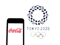In this photo illustration a Coca-Cola logo seen displayed on a smartphone with a Tokyo 2020 Olympic Games logo in the background. (