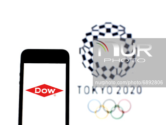 In this photo illustration a The Dow Chemical Company logo seen displayed on a smartphone with a Tokyo 2020 Olympic Games logo in the backgr...