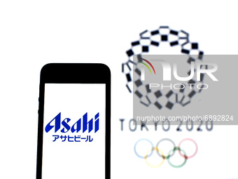In this photo illustration a Asahi Breweries, Ltd. logo seen displayed on a smartphone with a Tokyo 2020 Olympic Games logo in the backgroun...