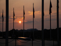 The sun sets beyond the Washington Monument in Washington, D.C. on July 21, 2021 amidst hazy skies brought on by smoke carried across the Un...