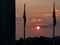 The sun sets beyond the Washington Monument in Washington, D.C. on July 21, 2021 amidst hazy skies brought on by smoke carried across the Un...