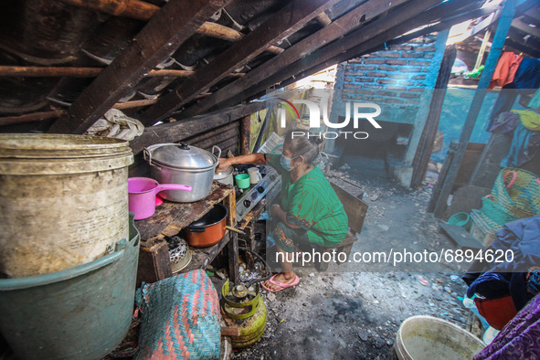 A woman cooks at her home in a fishing village in Tambaklorok, Semarang, Central Java Province, Indonesia on July 21, 2021. 