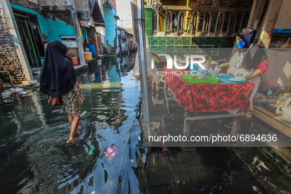 Residents' activities amid tidal flooding in a fishing village in Tambaklorok, Semarang, Central Java Province, Indonesia on July 21, 2021. 