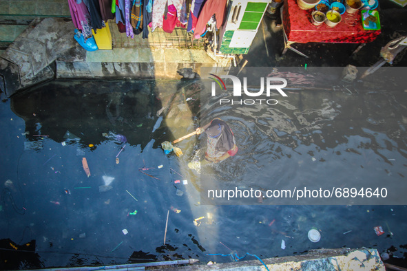 Residents' activities amid tidal flooding in a fishing village in Tambaklorok, Semarang, Central Java Province, Indonesia on July 21, 2021. 