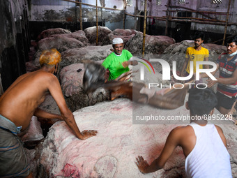 Workers applying salt on raw cattle skin for preservation at Posta area in Dhaka, Bangladesh on July 22, 2021.  (