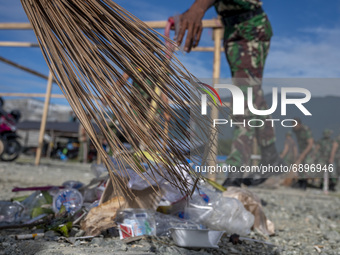 Indonesian Army soldiers pick up plastic waste scattered in the Talise Beach area, Palu, Central Sulawesi Province, Indonesia on July 23, 20...