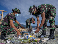 Indonesian Army soldiers collect plastic waste scattered in the Talise Beach area, Palu, Central Sulawesi Province, Indonesia on July 23, 20...