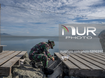 Indonesian Army soldiers pick up plastic waste scattered in the Talise Beach area, Palu, Central Sulawesi Province, Indonesia on July 23, 20...