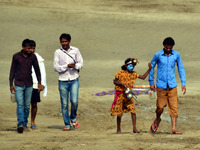 An indian boy,dressed as Hindu God Shiva,asks to devotee for money,who come to take a holy dip at sangam,confluence of River Ganga,Yamuna an...