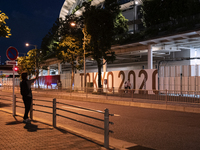 A man takes a picture of the National Stadium on the night before the opening ceremony of the Olympic Games in Tokyo, Japan on 22 July, 2021...