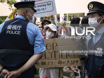 A elderly protestor holds a placard and call for the cancellation of the Tokyo Olympics in Tokyo, Japan on 23 July, 2021. (