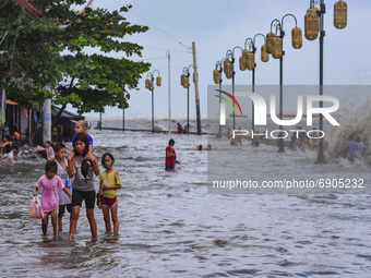 Children wade through floodwater near the shore of the polluted Manila Bay in Tondo district, Manila City, Philippines on July 26, 2021. Typ...