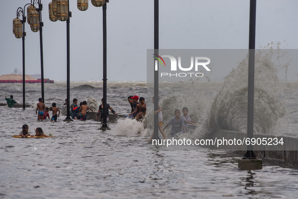 Children play in floodwater near the shore of the polluted Manila Bay in Tondo district, Manila City, Philippines on July 26, 2021. Typhoon...