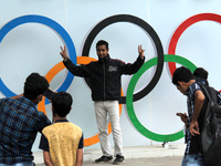 People take pictures with Olympic rings as they celebrate arrival of India's weightlifter Mirabai Chanu who won the silver medal in Tokyo Ol...