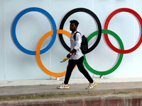 A man walks past Olympic rings as people celebrate arrival of India's weightlifter Mirabai Chanu who won the silver medal in Tokyo Olympics...