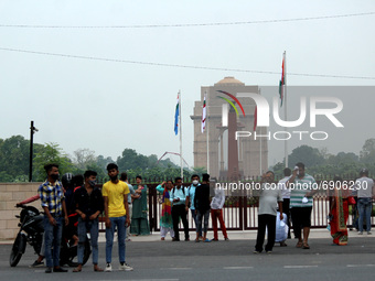 People click pictures at the India Gate War memorial, as they gather to pay tribute to Kargil martyrs during the 22nd anniversary of India's...