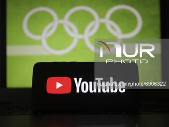 YouTube  logo is displayed on a mobile phone screen photographed with Olympic rings symbol on the background for illustration photo. Leszcze...