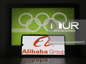 Alibaba Group logo is displayed on a mobile phone screen photographed with Olympic rings symbol on the background for illustration photo. Le...