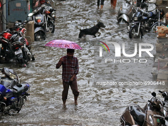 A commuter wade through a waterlogged street during rain in Jaipur, Rajasthan, India, on July 26, 2021. (