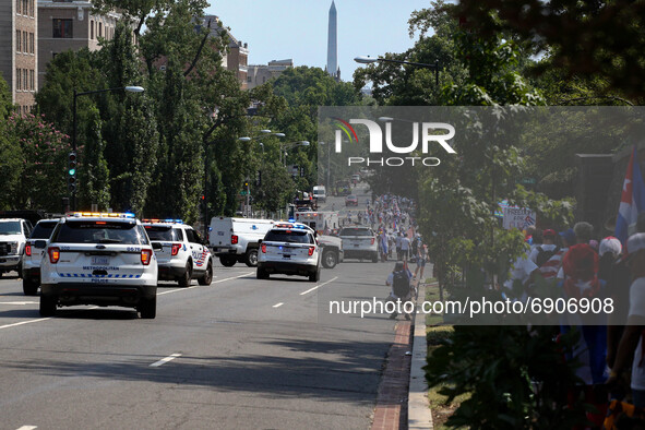 Police vehicles block a street as thousands of demonstrators opposing Cuba's government gather outside of the Cuban Embassy in Washington, D...