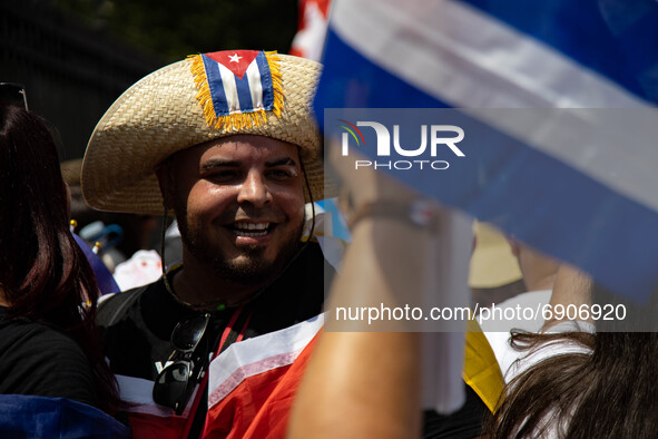 A man smiles as thousands of demonstrators opposing Cuba's government gather outside of the Cuban Embassy in Washington, D.C. after a march...