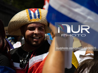 A man smiles as thousands of demonstrators opposing Cuba's government gather outside of the Cuban Embassy in Washington, D.C. after a march...