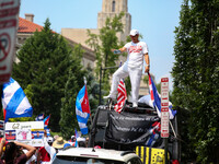 A man stands on top of a vehicle as thousands of demonstrators march from the White House to the Cuban Embassy in Washington, D.C. on July 2...