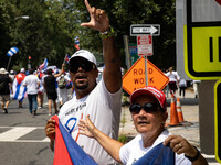 A demonstrator displays a 'L' hand gesture during a march from the White House to the Cuban Embassy in Washington, D.C. on July 26, 2021 (