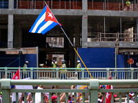 A demonstration for Cuban rights passes a construction crew during a march from the White House to the Cuban Embassy in Washington, D.C. on...