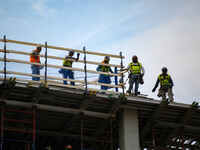 Construction workers watch from the top of a building as thousands of demonstrators march from the White House to the Cuban Embassy in Washi...