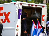 A FedEx worker watches as thousands of demonstrators march from the White House to the Cuban Embassy in Washington, D.C. on July 26, 2021 (