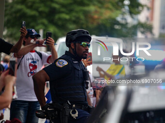 A Washington, D.C. Metropolitan Police officer watches on as thousands of demonstrators march from the White House to the Cuban Embassy in W...