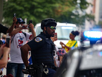 A Washington, D.C. Metropolitan Police officer watches on as thousands of demonstrators march from the White House to the Cuban Embassy in W...