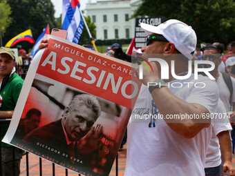 A man yells and holds a sign during a demonstration for Cuban rights near the White House on July 26, 2021 (