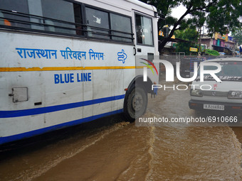 Indian People drives past a flooded street after heavy monsoon rains in Ajmer, Rajasthan, India on 27 July 2021.  (
