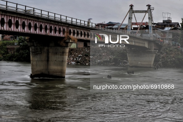 Commuters walk over a brigde during Rainfall in Sopore, District Baramulla Jammu And Kashmir, India on 28 July 2021. 4 dead, 36 missing afte...