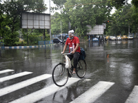A Zomato delivery boy rides a bicycle during heavy rainfall in Kolkata, India, 28 July, 2021.  (