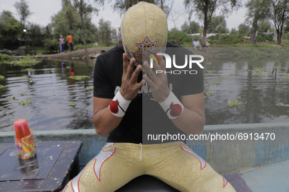 Gran Felipe Jr., a professional wrestler, aboard a boat as he adjusts his mask before a wrestling match where he goes head to head with othe...