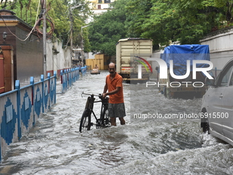 A man with his bicycle struggles in water logged street in Kolkata, India, on July 30, 2021. (