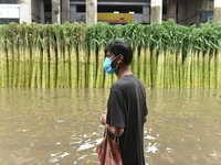 People wade through a waterlogged street  in Kolkata, India, on July 30, 2021. (