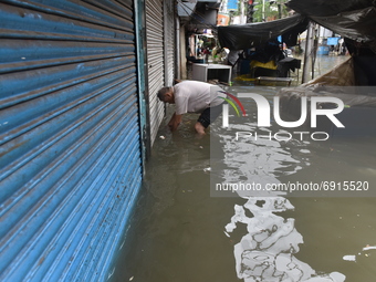 A shopkeeper is seen unlocking his shop as the locks are completely under the water in Kolkata, India, on July 30, 2021. (