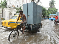 A man pulls his cart through the water logged street  in Kolkata, India, on July 30, 2021. (