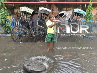 A municipal worker is seen guarding a manhole opening to drain the logged water from the street in Kolkata, India, on July 30, 2021. (