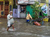 A man carries a LPG gas cylinder amidst a flooded street in Kolkata , India , on 30 July 2021 .LPG gas cylinder prices were hiked over 140 R...