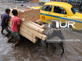 People make their way through a flooded Street  at the Heavy monsoon rains in Kolkata on July 30,2021. (