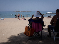 Locals and tourists are enjoying the warm weather and take a swim at Nea Chora beach near Chania, Crete Island, Greece on July, 31, 2021. (