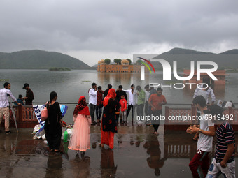 People enjoy at ' Jal Mahal' as clouds hover over it on a rainy day during the monsoon season in Jaipur, Rajasthan, India, Saturday, July 31...